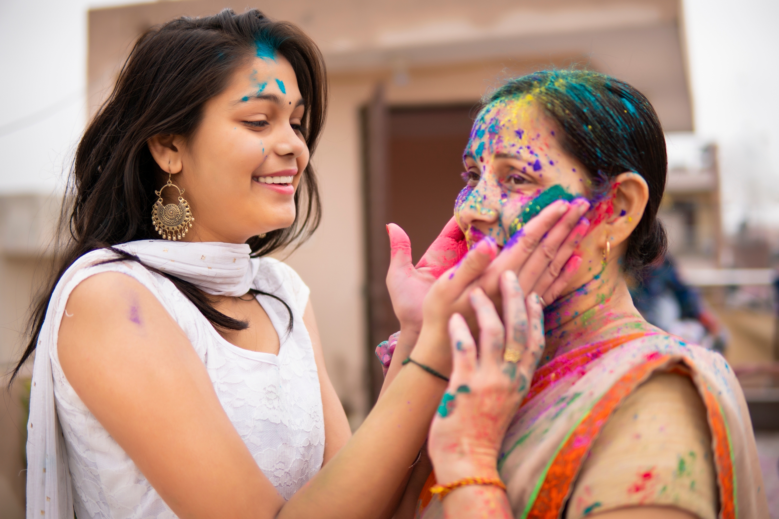 Two women celebrating the Holi festival with coloured powder.