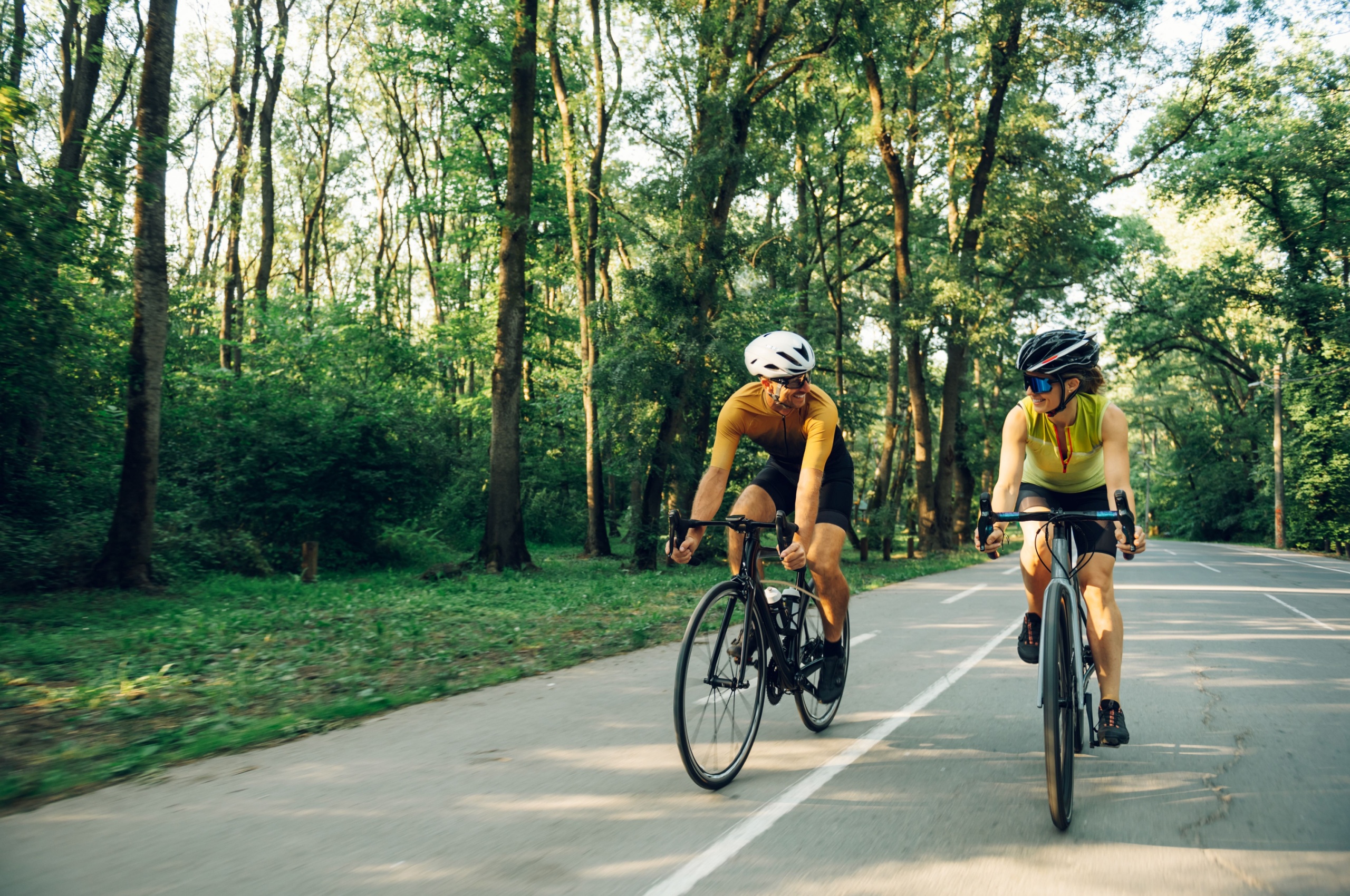 A couple cycling together on a road.