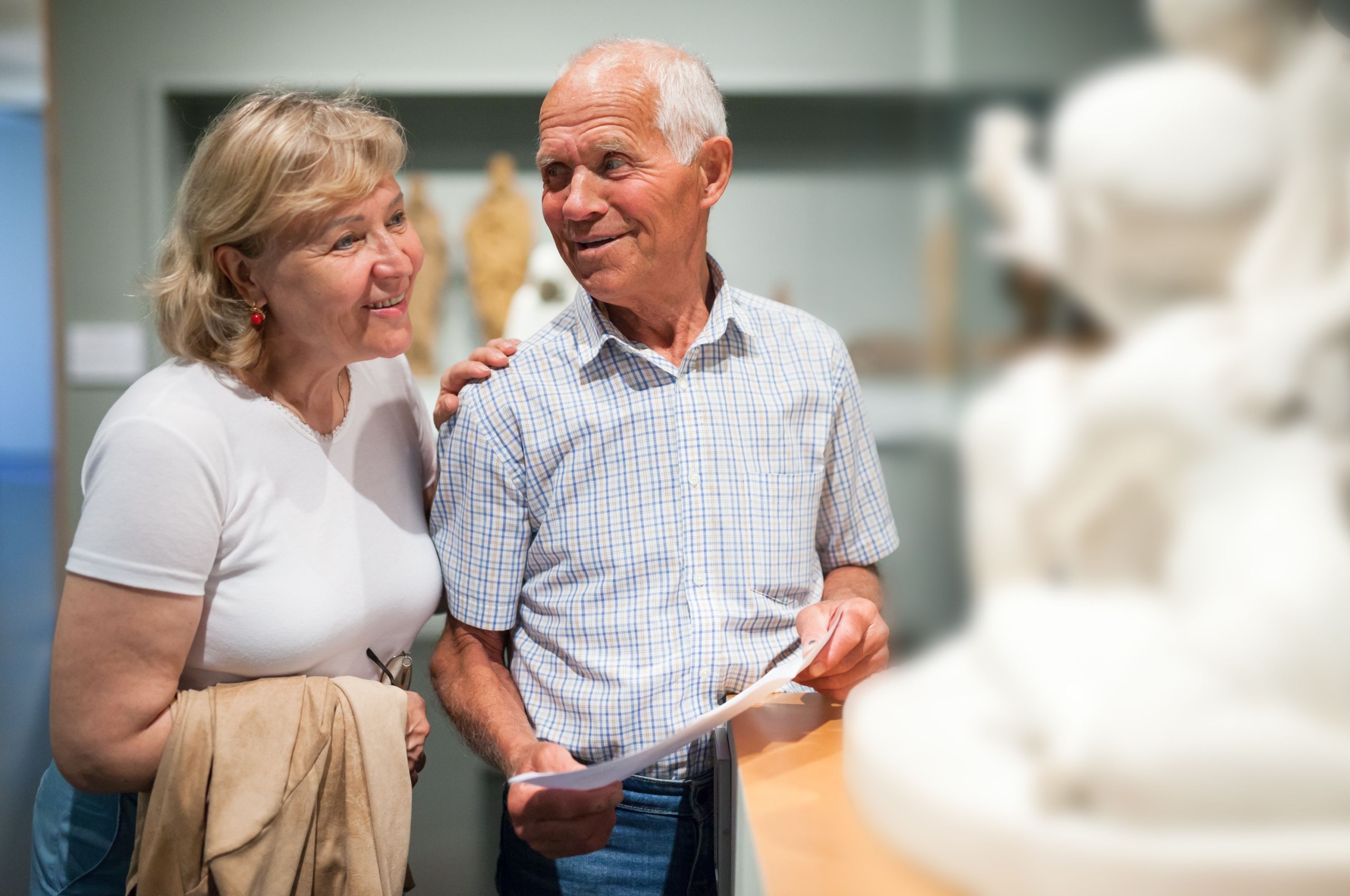 A couple looking at a statue in a museum