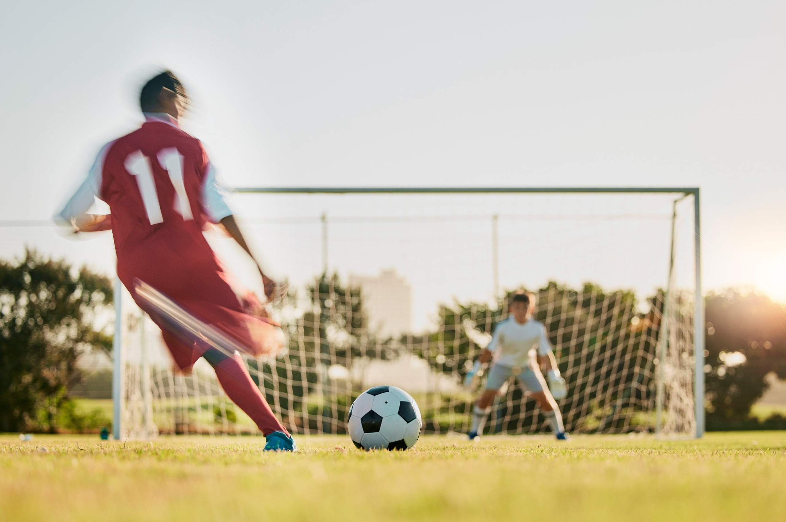 A footballer taking a shot at a goal.