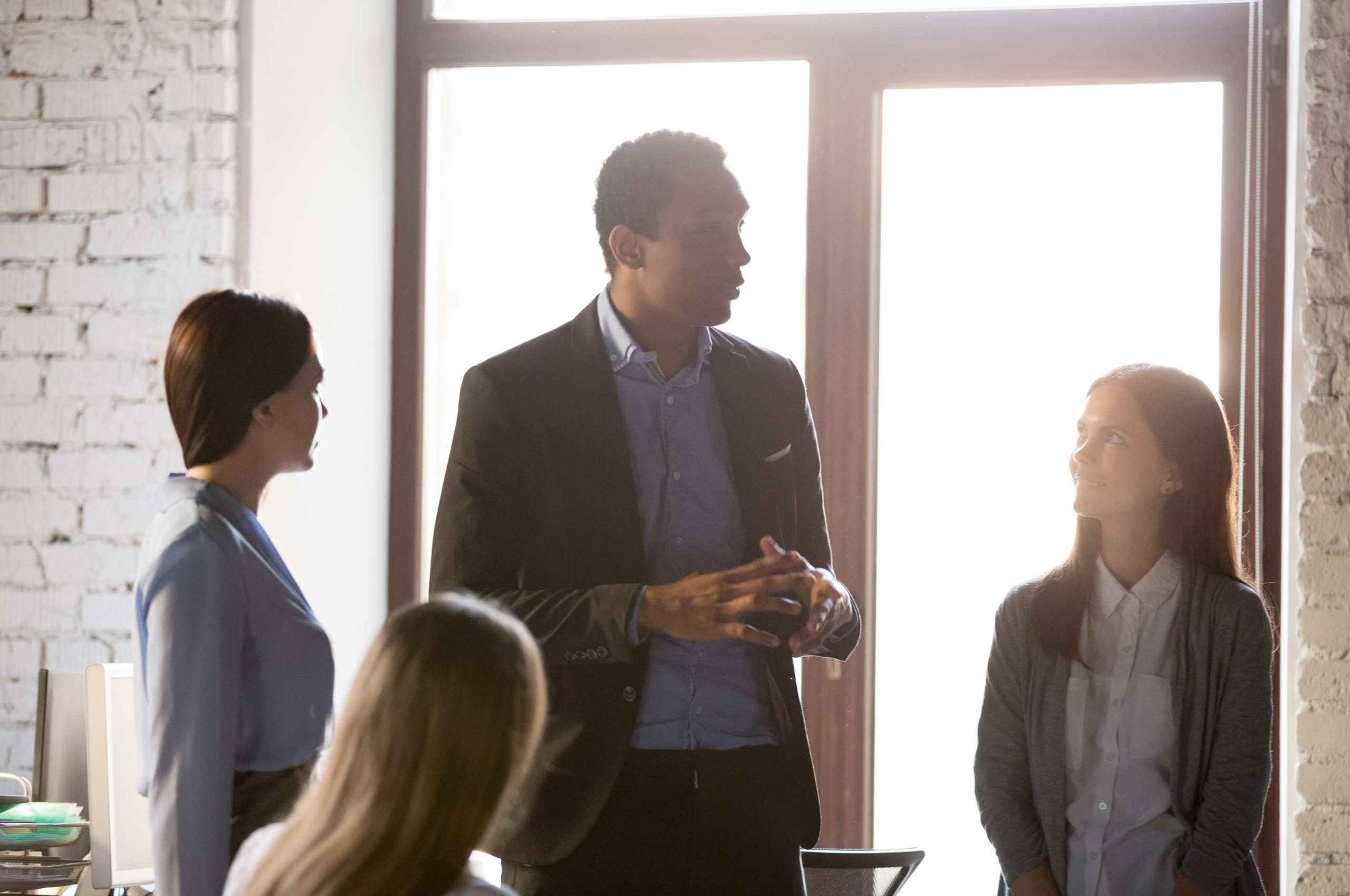 A business owner speaking with his employees.