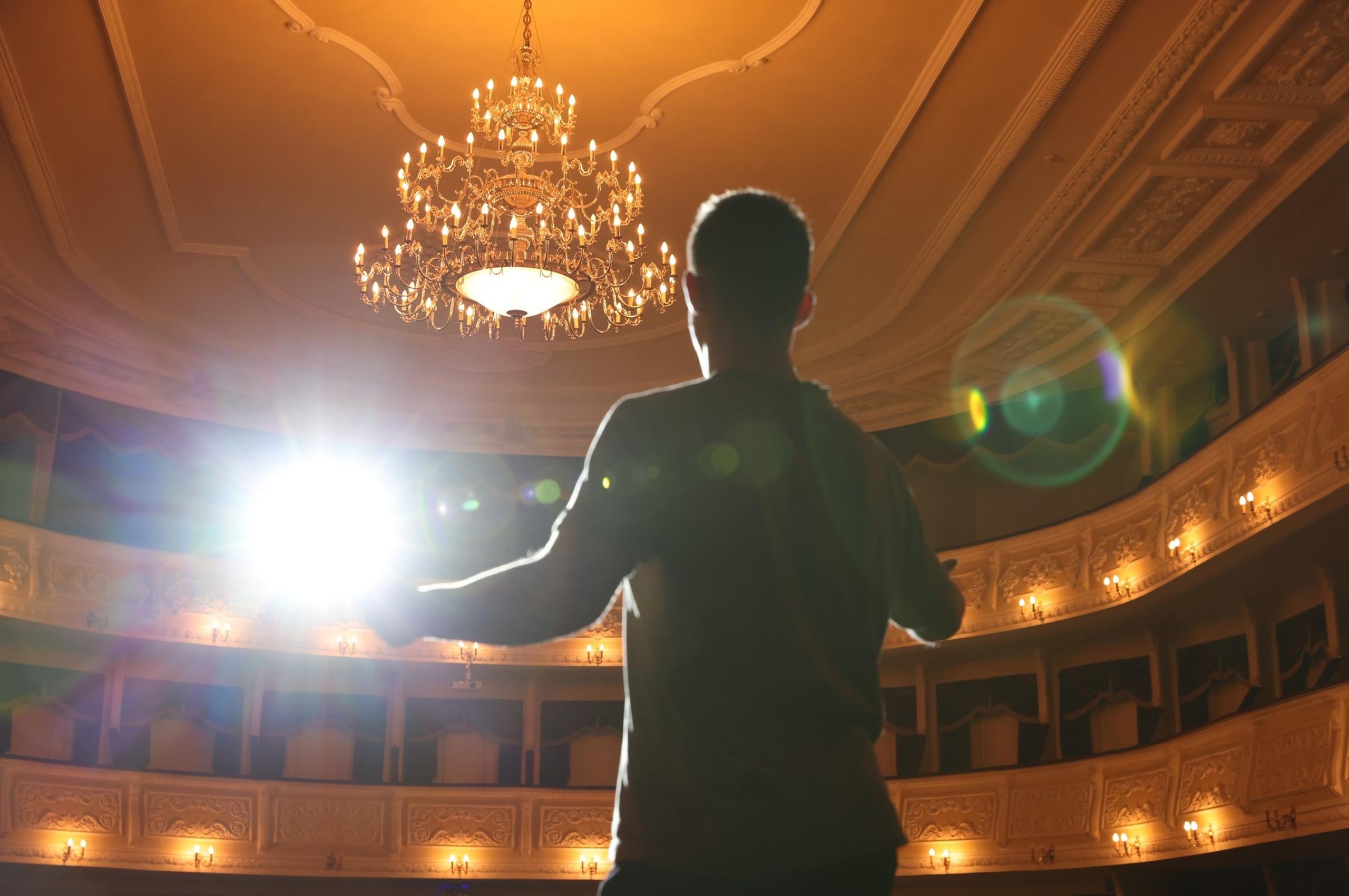 An actor rehearsing on a theatre stage.