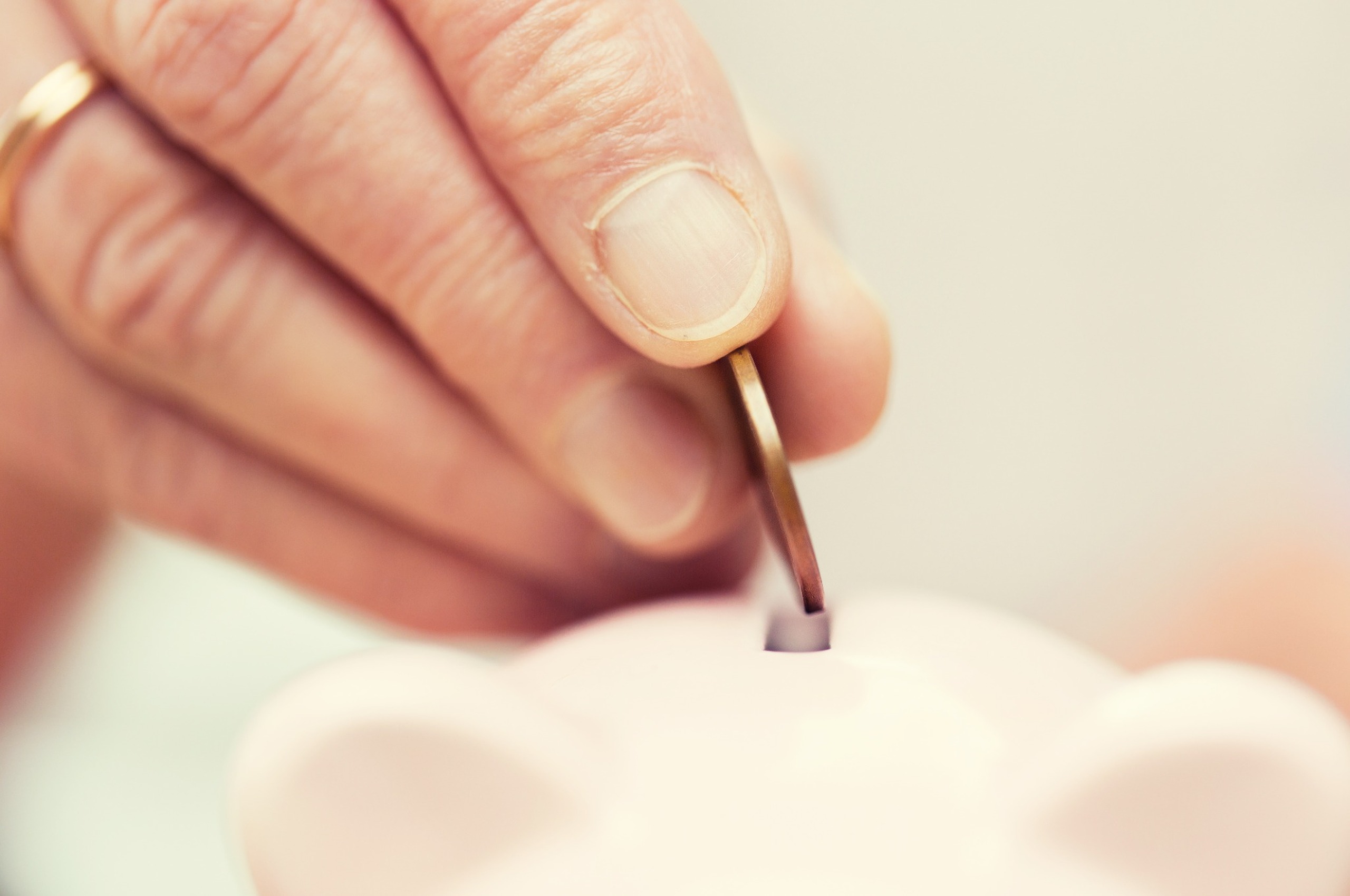 A person putting a coin into a money box.