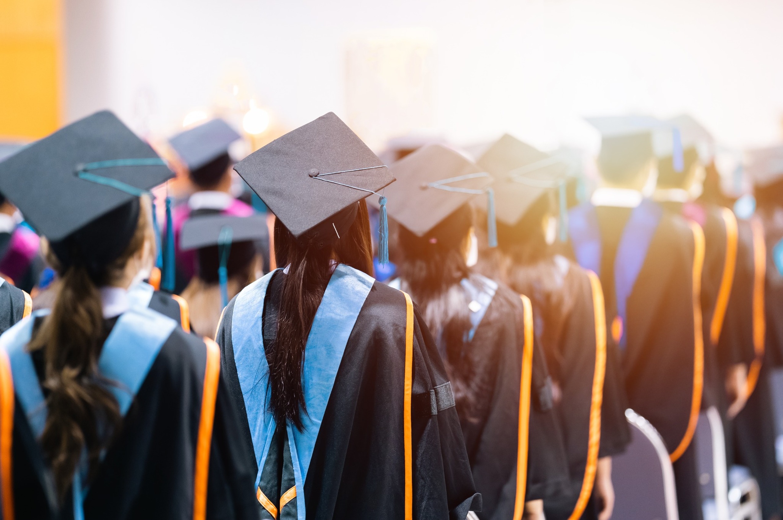 University students graduating wearing caps and gowns.
